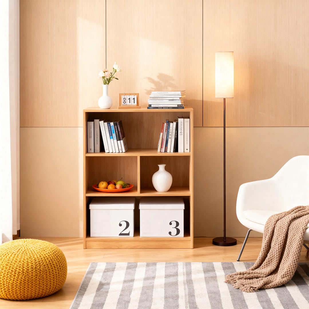 Black wrought iron floor lamps positioned near wooden shelving with decorative items and textiles