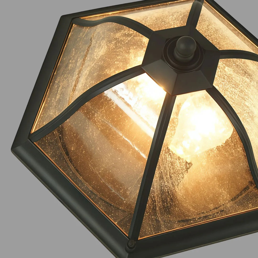Bottom view of a black flush mount light fixture featuring a geometric frame and seeded glass panels.