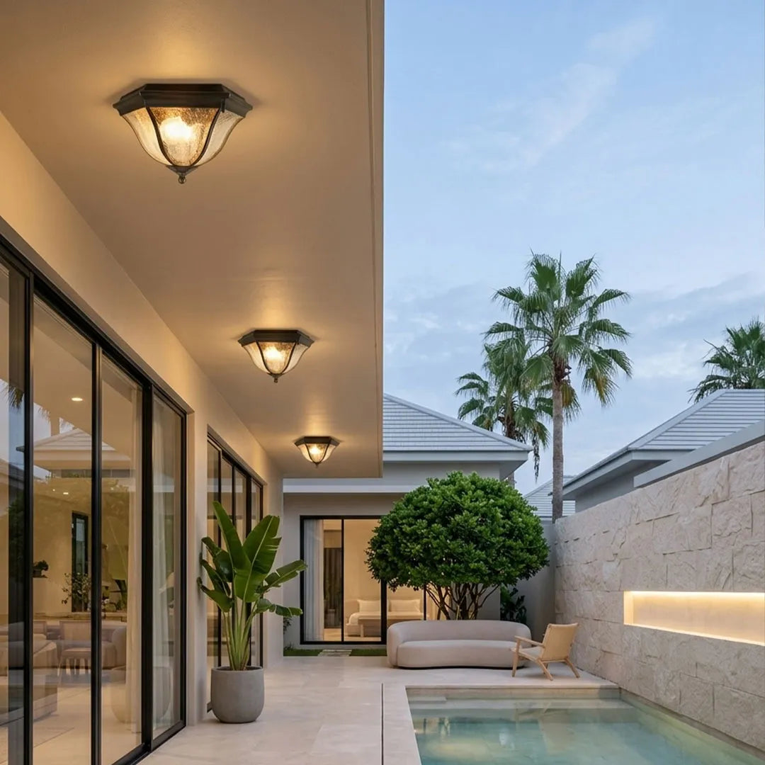 Black flush mount light fixtures providing warm lighting along a contemporary outdoor walkway.