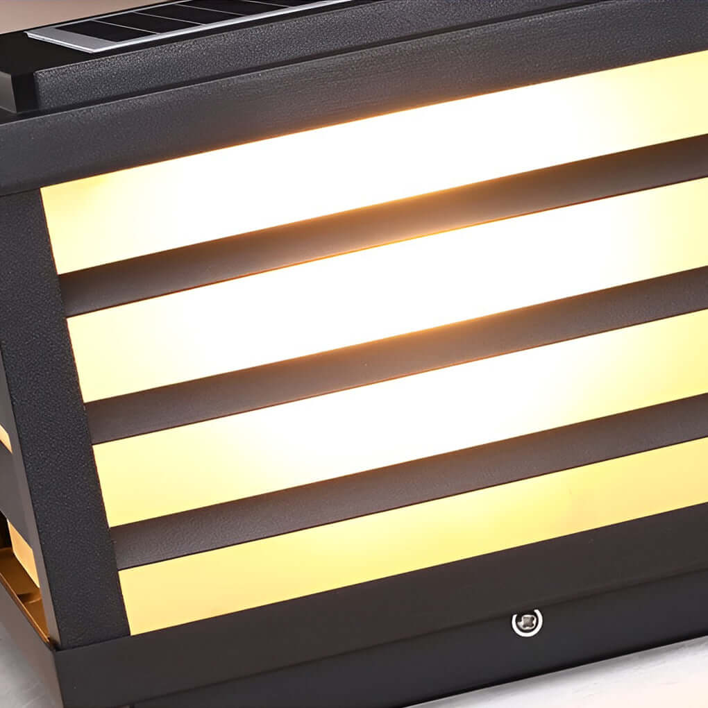 Close-up of a black gate pillar light, highlighting its sleek rectangular design and warm illumination.