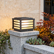 Black gate pillar light with a modern rectangular design, installed on a stone pillar for elegant outdoor illumination.
