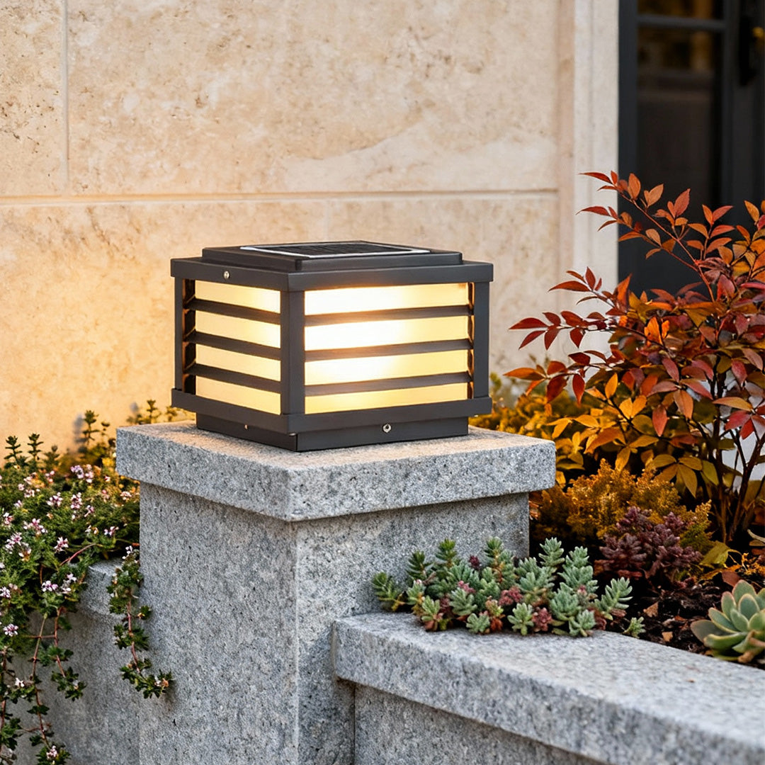 Black gate pillar light with a modern rectangular design, installed on a stone pillar for elegant outdoor illumination.