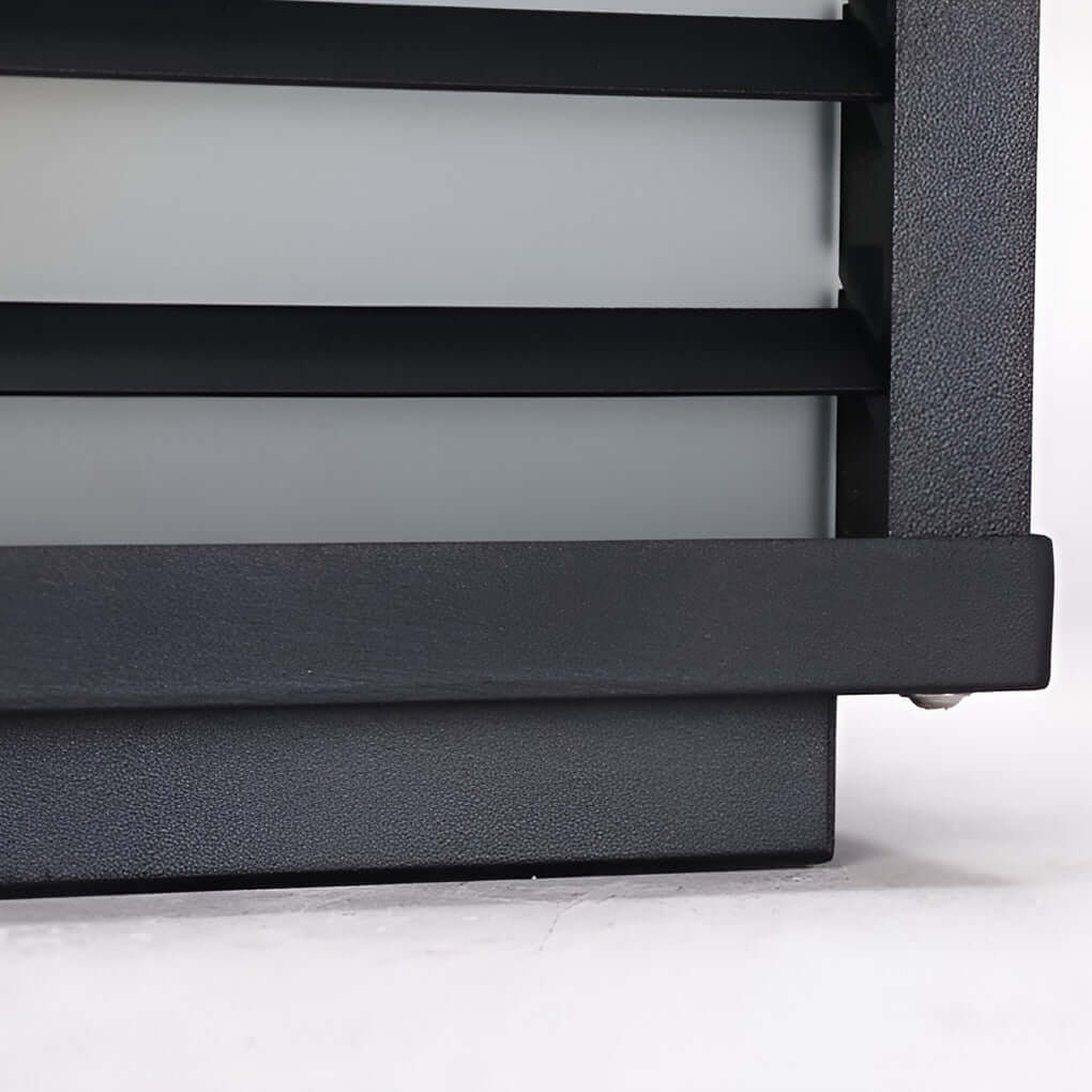 Black gate pillar light with a rectangular design, installed on a stone pillar for modern outdoor lighting.