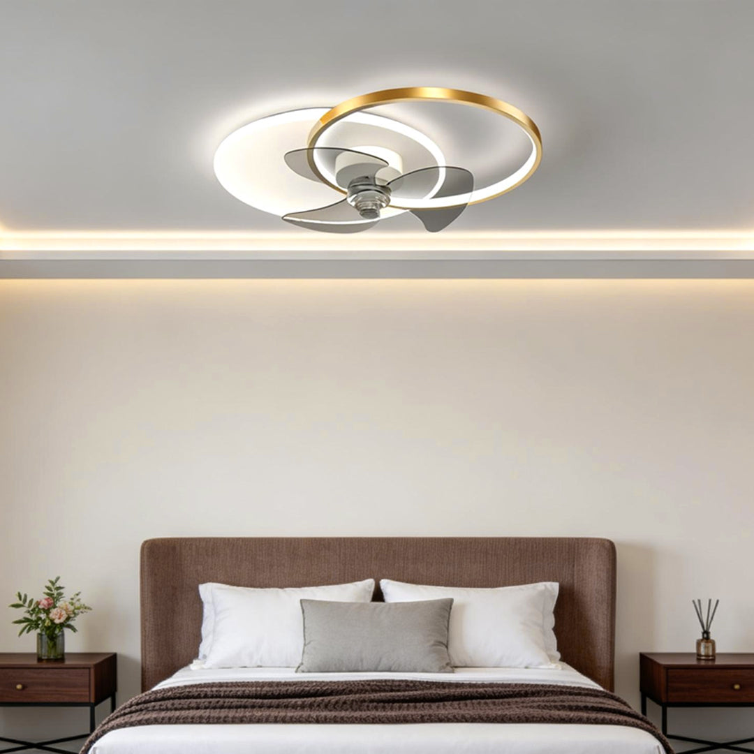 Black and gold accented ceiling fan with light in a contemporary bedroom interior.