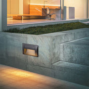 Black rectangular recessed wall light fixture with hooded design for directional outdoor illumination