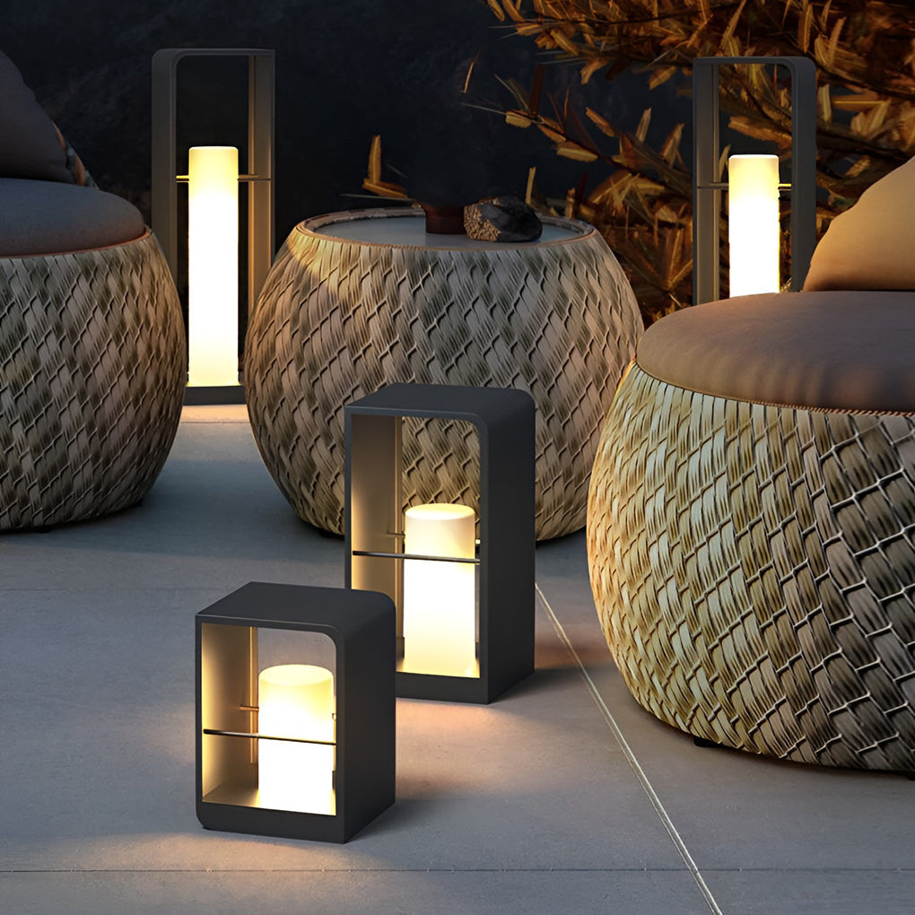 Black lantern outdoor light with cylindrical shape, providing soft light near poolside furniture.