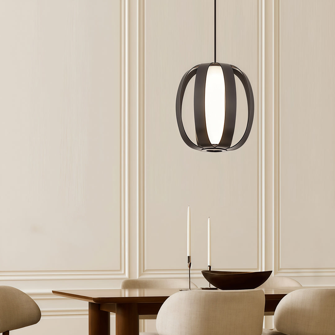 Black lantern pendant light brightening traditional dining room with paneled walls and candles.