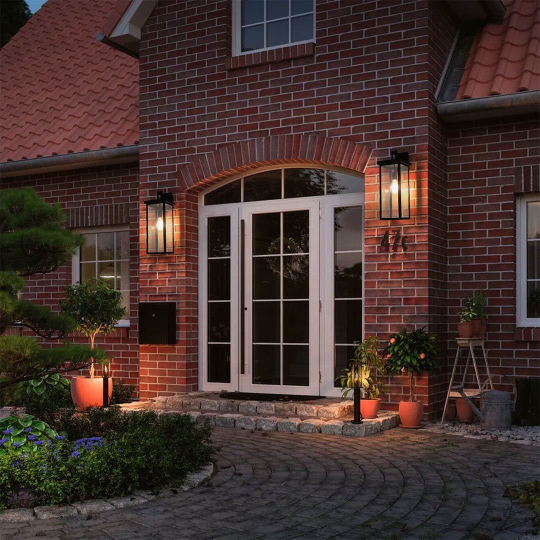Black exterior lantern wall light illuminating a brick house entrance, adding charm and safety to the outdoor space.