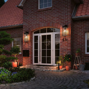Black exterior lantern wall light illuminating a brick house entrance, adding charm and safety to the outdoor space.