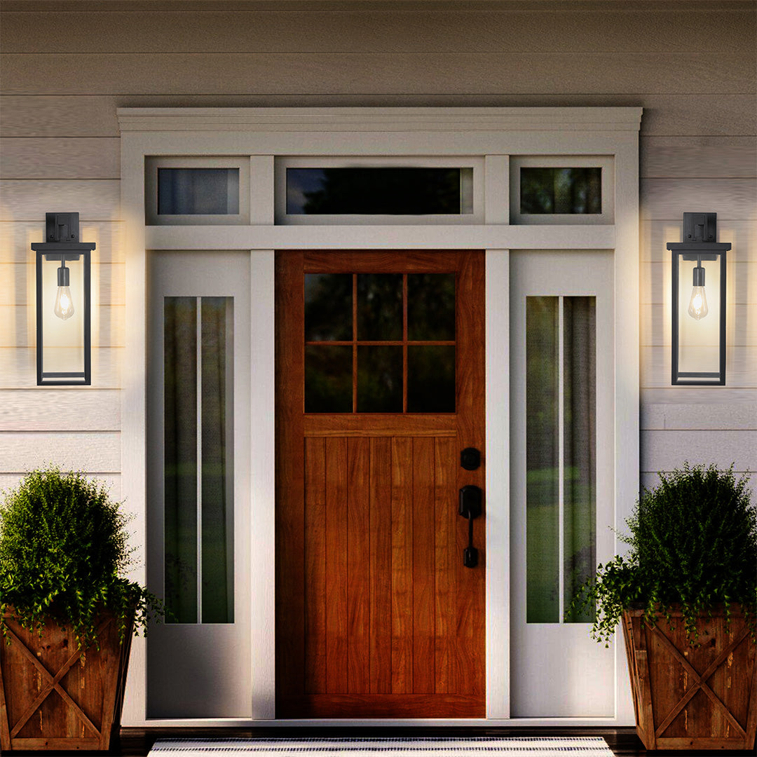Black exterior lantern wall lights installed above a wooden door, enhancing curb appeal with warm, inviting light.