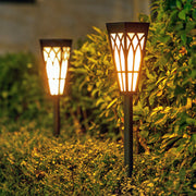 Warm LED solar pathway lights creating ambient lighting in landscaped garden setting