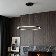 Modern black LED ring chandelier suspended above fireplace in contemporary living room.