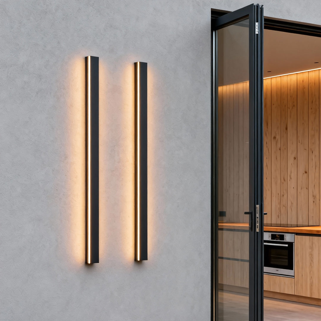 Black linear wall light with a close-up of its illuminated vertical structure.