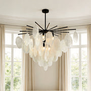 Striking black metal mother of pearl chandelier featuring cascading textured round discs suspended in a bright, elegant room.