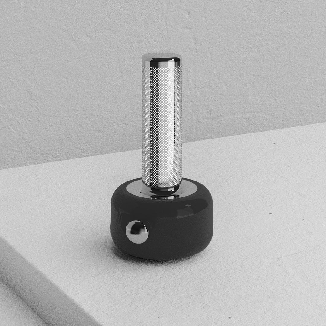 Black industrial metal USB rechargeable table lamp positioned on concrete surface showing durability