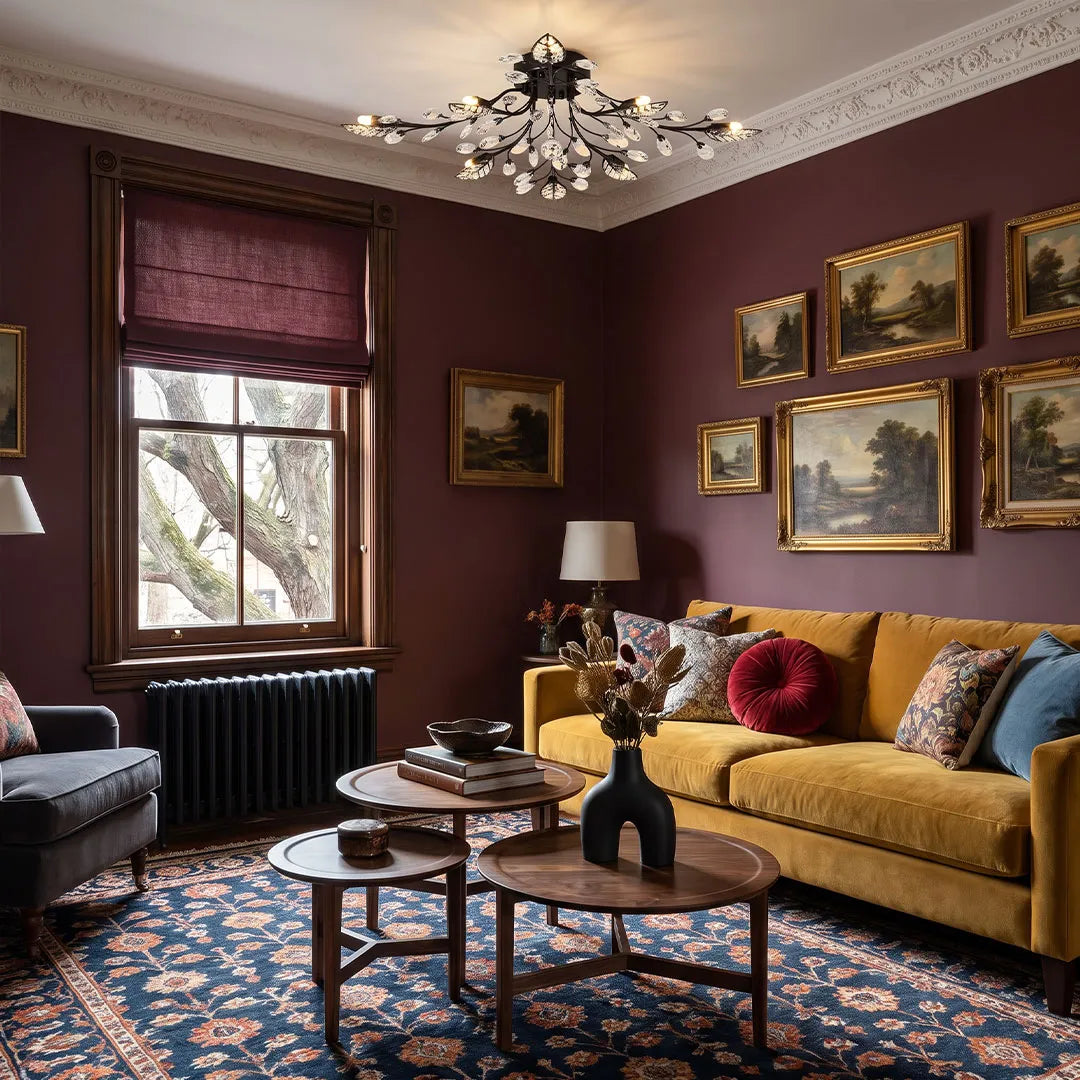 Black modern branch chandelier with crystal drops lighting a cozy living room with burgundy walls and framed artwork.