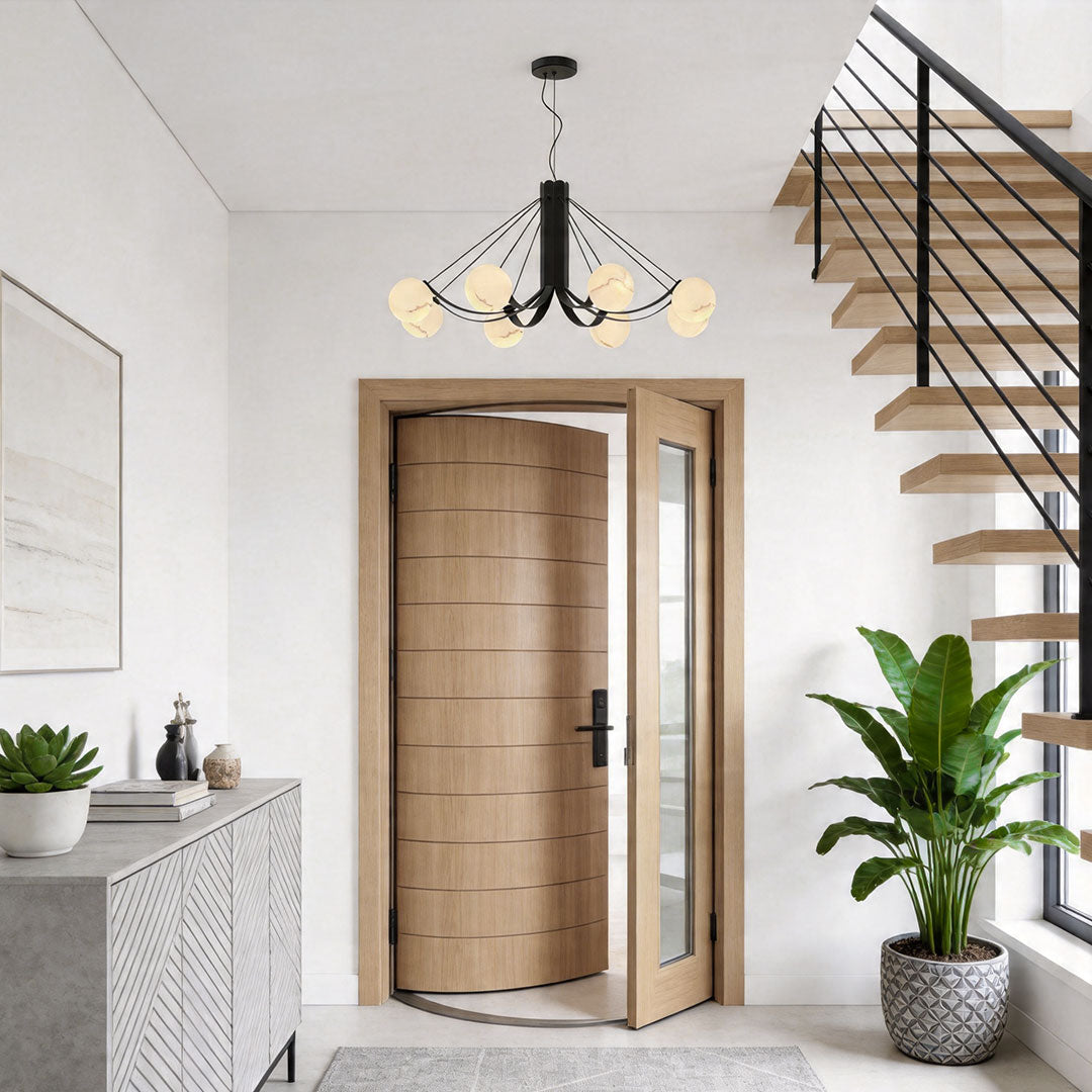 Black modern chandelier lighting fixture in an entryway with staircase and clean architectural lines.