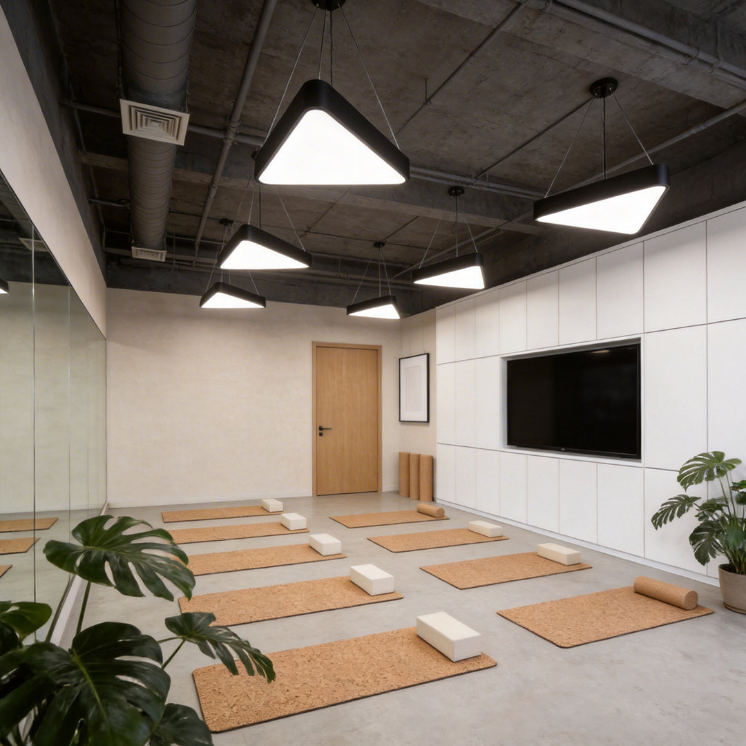 Black modern chandeliers illuminating a modern office corridor with soft glow.