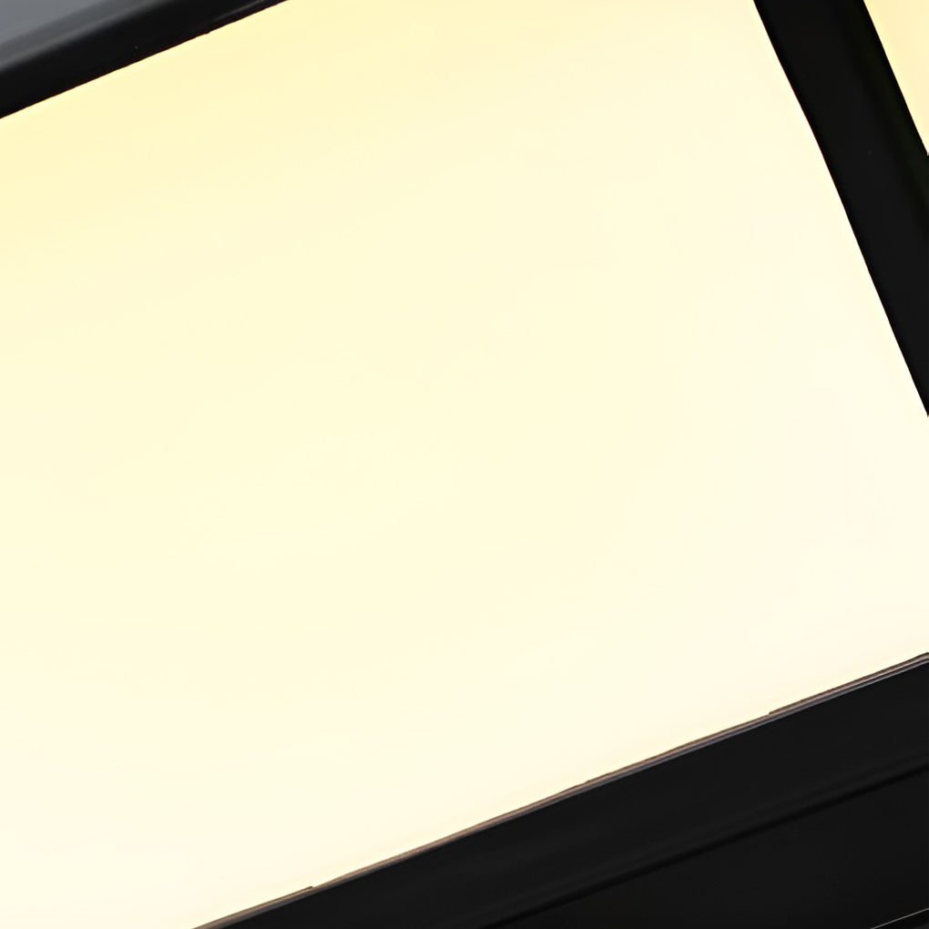 Black modern outdoor pillar light with a pyramid roof, providing a warm glow on a stone pillar in a garden setting.