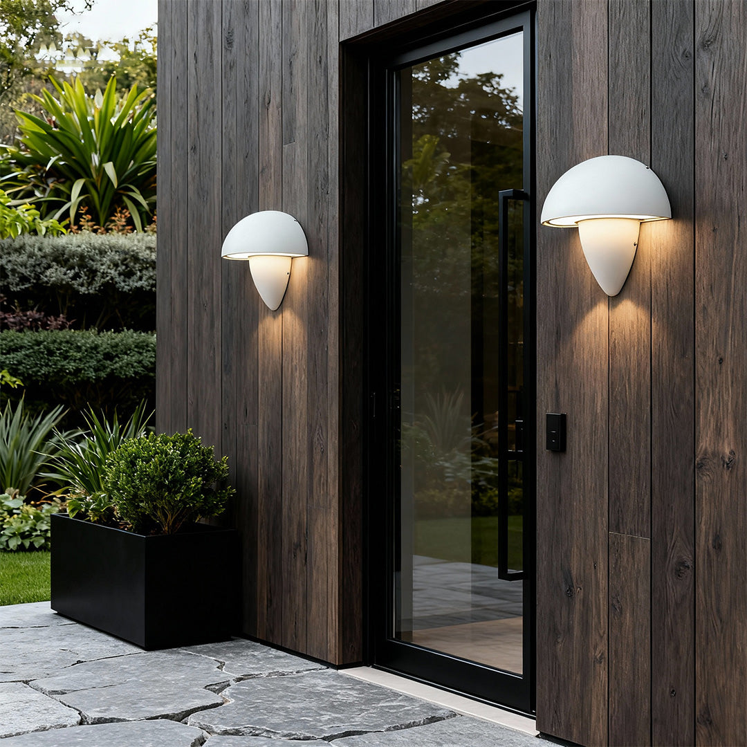 Black mushroom wall light on a dark gray wall, casting dramatic lighting in a contemporary urban environment.