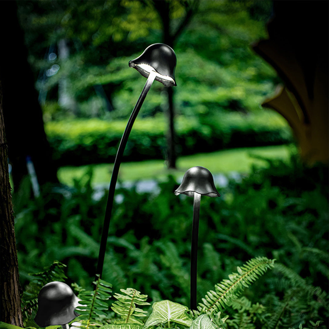 Contemporary black outdoor landscape light with sleek design integrated into lush tropical garden environment