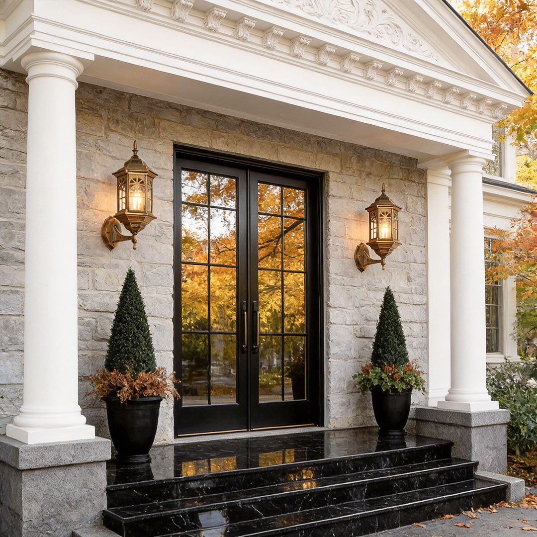 Black outdoor lantern sconce providing soft illumination beside a classic entrance.