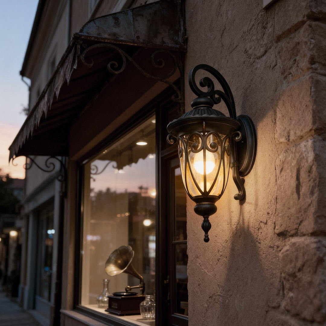 Black outdoor lantern sconce mounted beside a stone building entrance, providing classic and warm illumination.