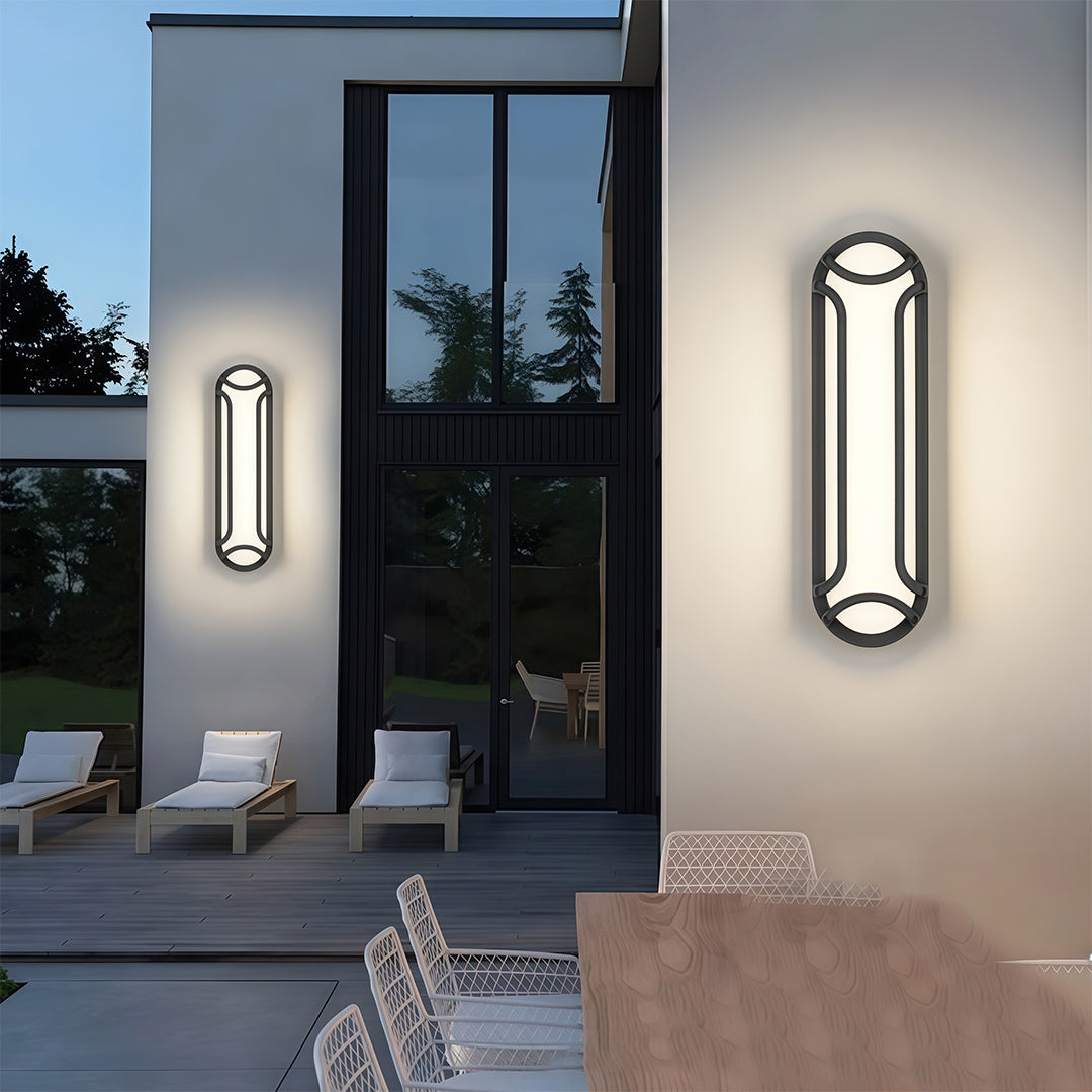 Black outdoor wall sconce with a modern design, providing bright, even illumination for an outdoor pathway.