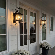 Black outdoor sconces mounted beside French patio doors, adding classic lantern-style lighting to the exterior entry.