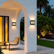 Contemporary black outdoor up and down wall lights installed on an archway exterior, casting warm symmetrical light.
