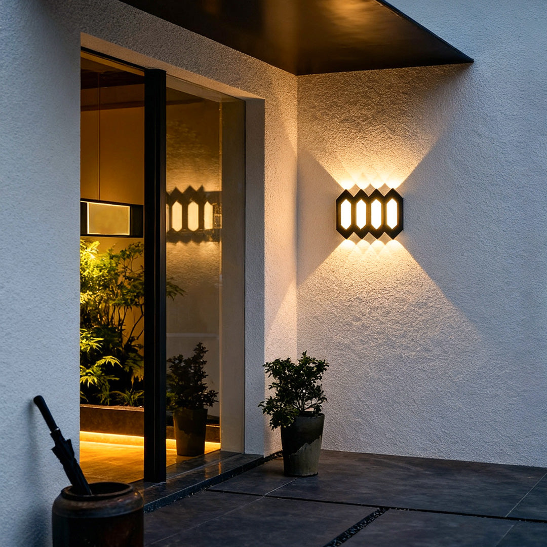 Sleek black outdoor up and down wall lights brightening a modern patio entrance with warm dual-direction lighting.