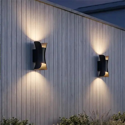 Black outdoor up and down wall lights on a wood-paneled exterior wall