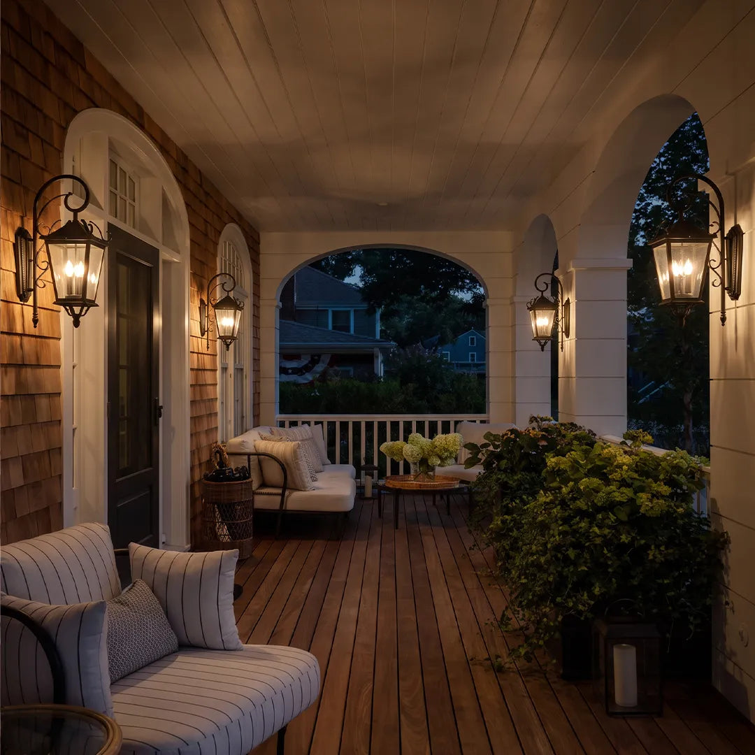 Black outdoor wall lights lining a covered porch, creating a warm and inviting lantern-lit outdoor seating space.