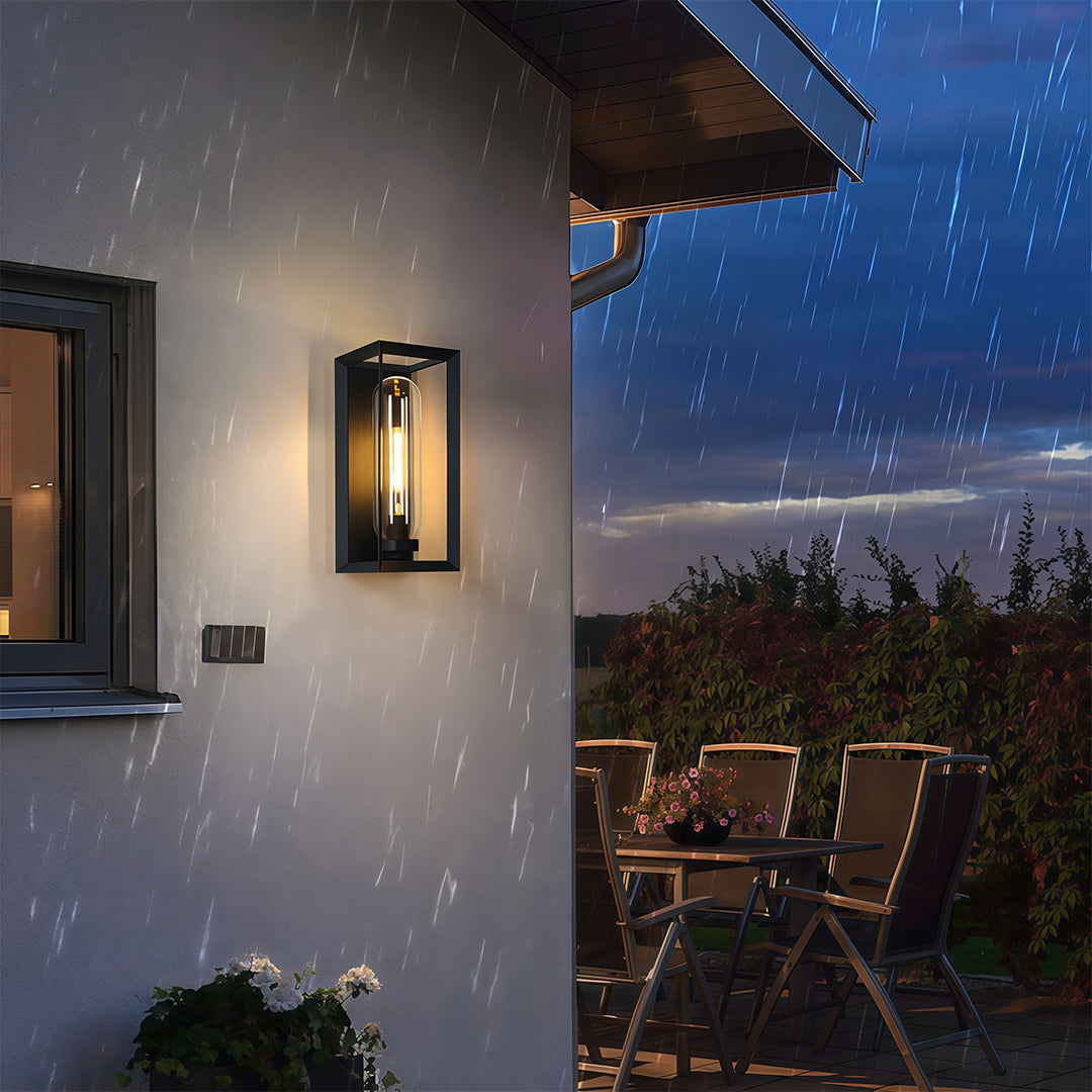 Black outdoor wall sconce modern fixture providing ambient lighting on evening patio setting