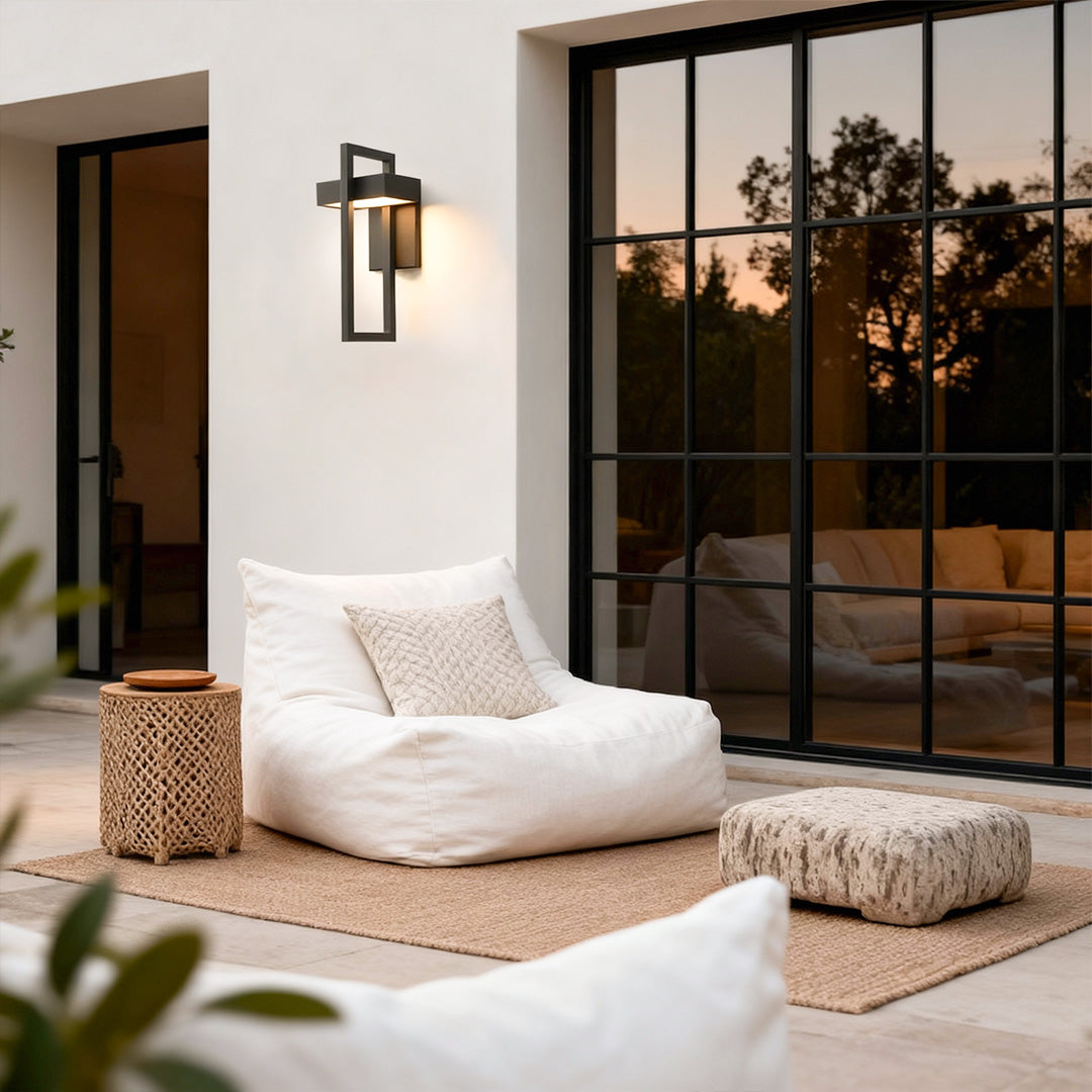 Outdoor black outdoor wall sconce modern mounted along a wooden fence, creating a modern pathway lighting effect.