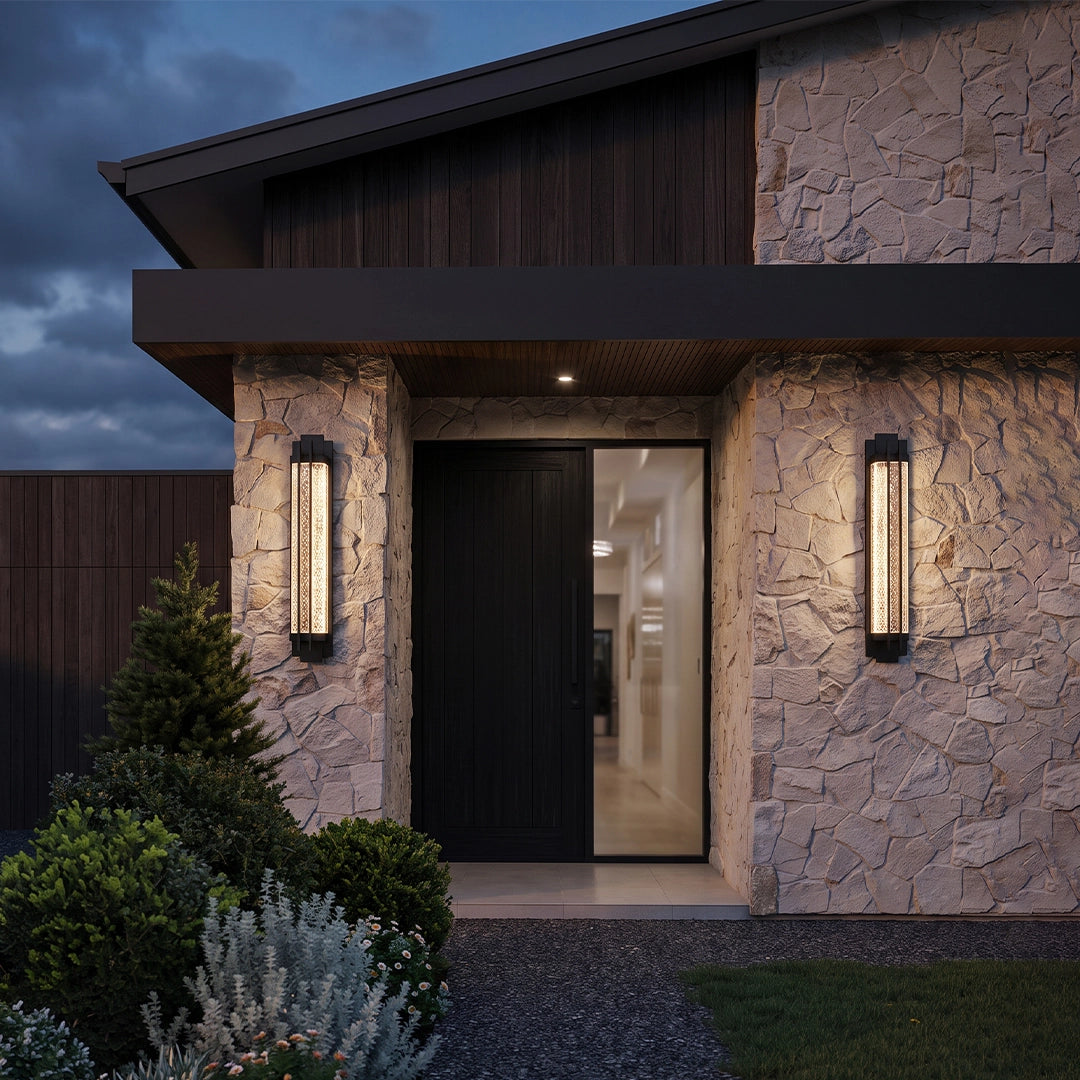Black outside wall lights installed beside a contemporary stone home entrance for warm illumination.