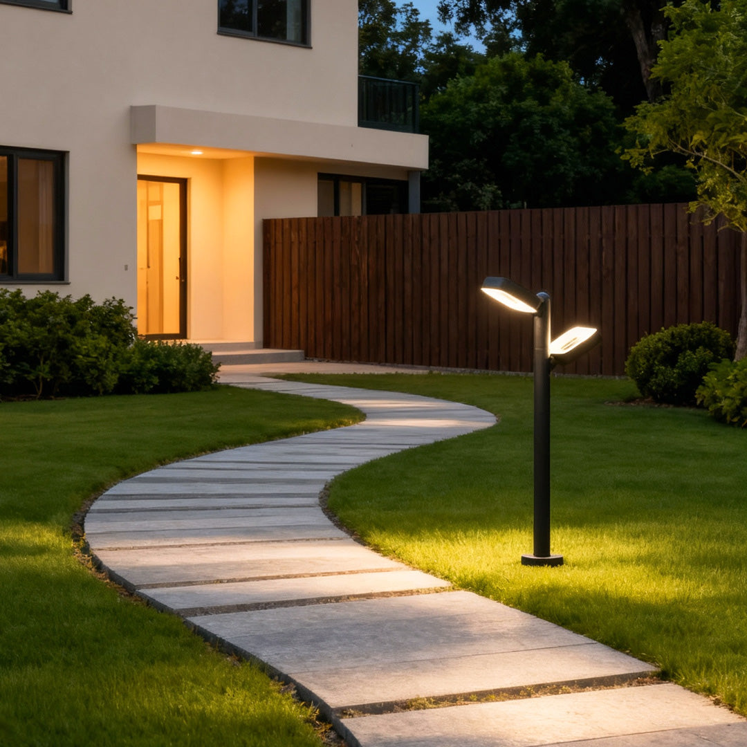 Stylish black path light positioned beside a landscaped walkway leading to a contemporary house.
