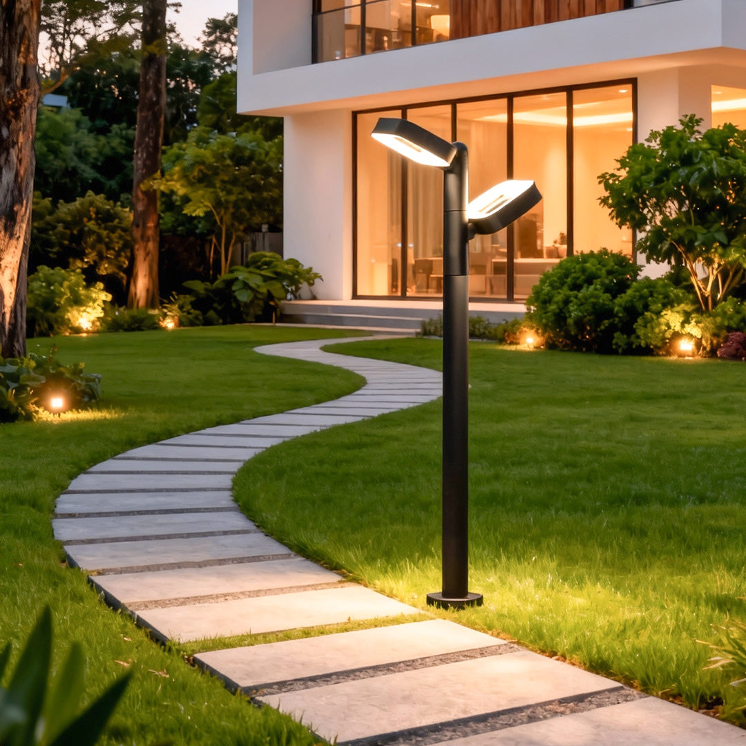 Contemporary black path light lighting a curved stone walkway in a warm outdoor setting.
