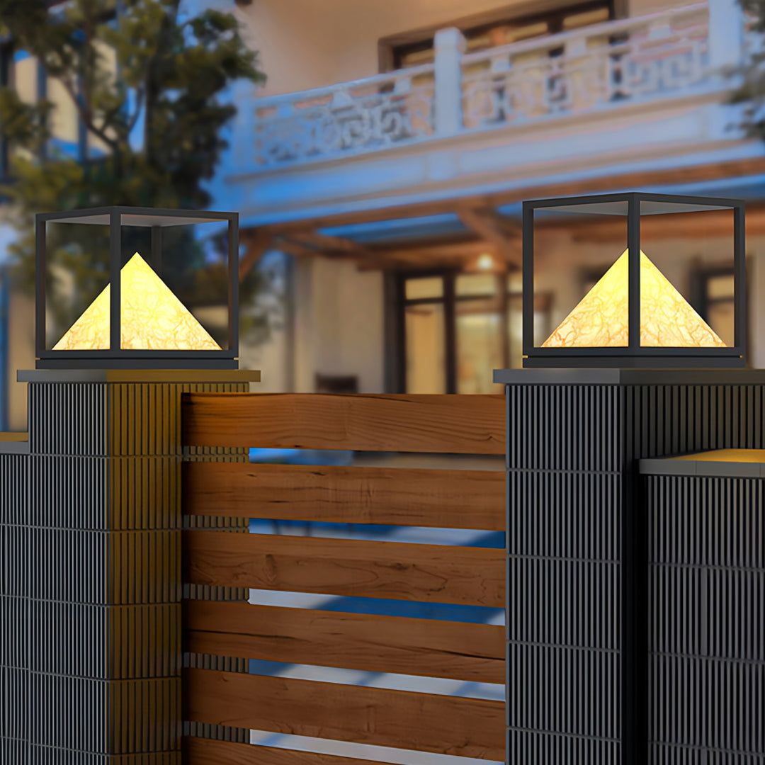 Artistic close-up of outdoor lantern with pyramid diffuser in warm light pillar design.