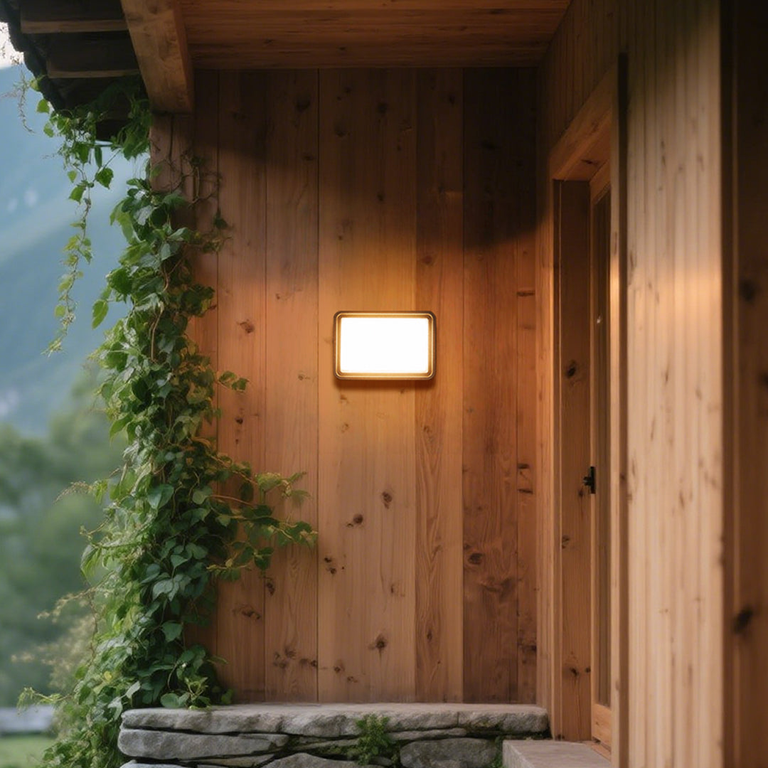 Outdoor wall light with angled black housing and directional beam capabilities