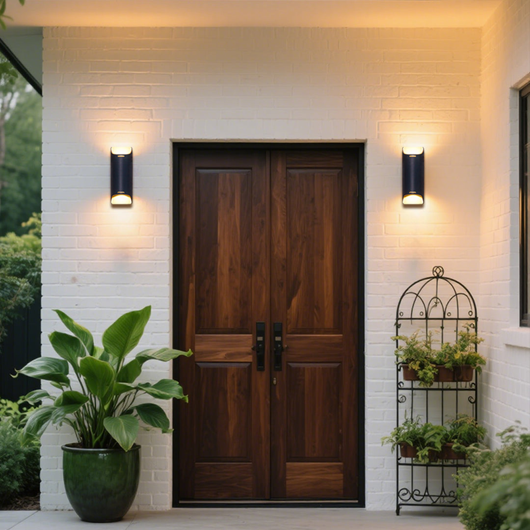 Contemporary black rectangular wall sconce with clean lines mounted on natural stone exterior surface