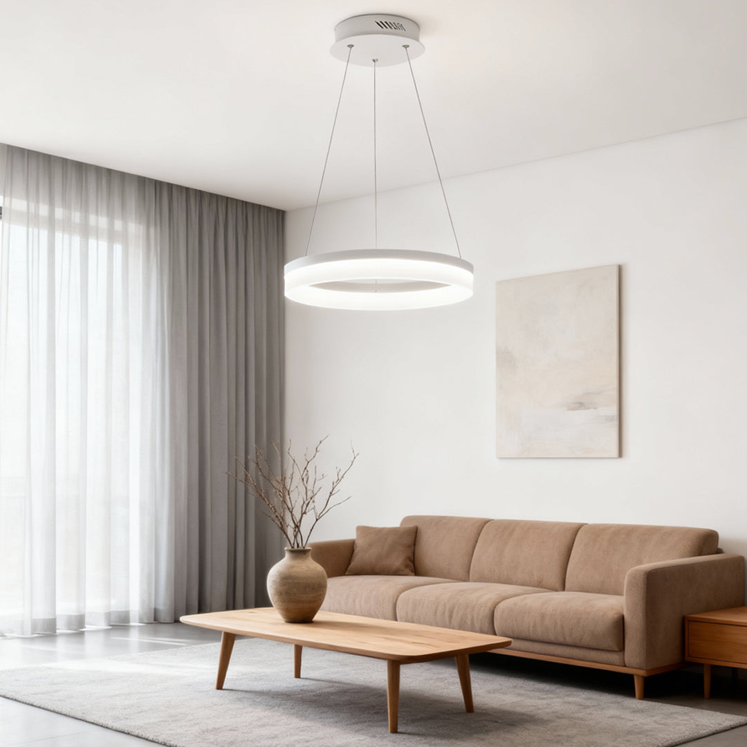Black ring pendant light hanging in a bright living room with sheer curtains and neutral furniture.