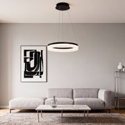 Modern black ring pendant light installed above a minimalist living room sofa with soft ambient lighting.