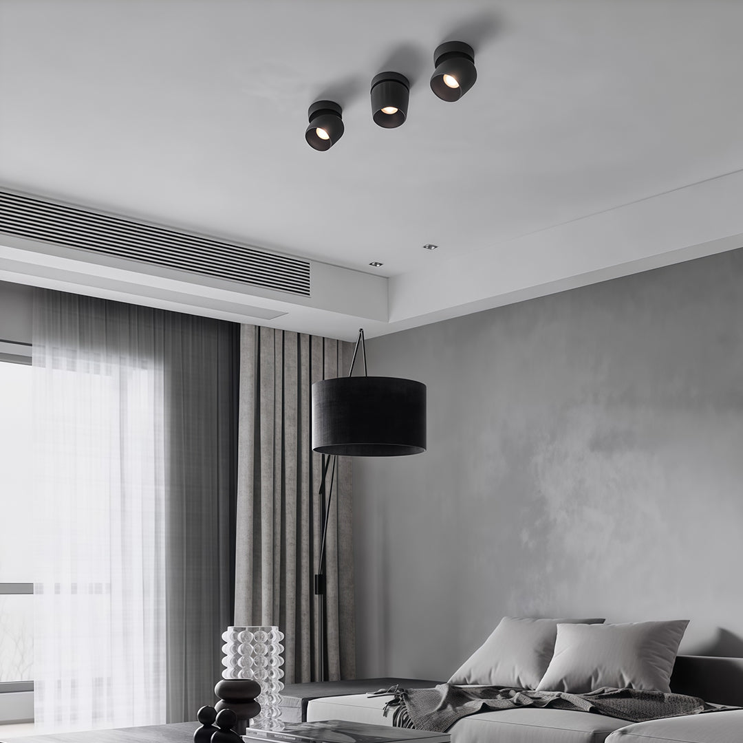 Black rotating spotlights adding drama to contemporary grey bedroom with striped window treatment