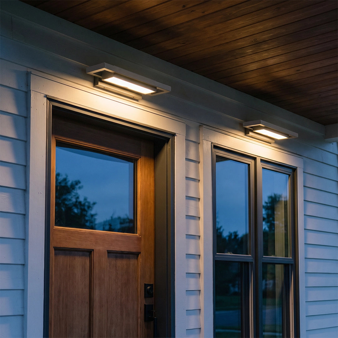 Black sconce wall lights installed above exterior doors beneath a dark wood porch ceiling.