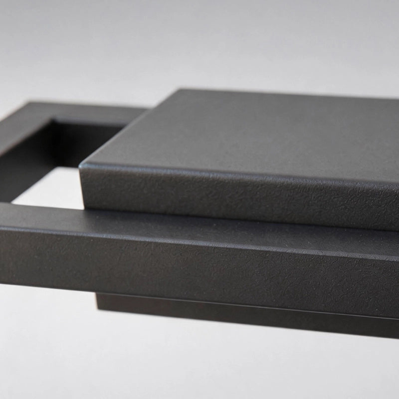 Black sconce wall lights close-up highlighting the layered rectangular metal construction.