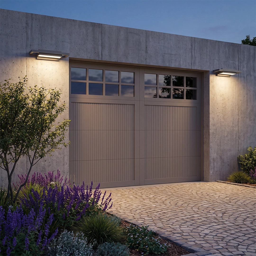 Black sconce wall lights mounted beside a garage to provide warm exterior illumination.