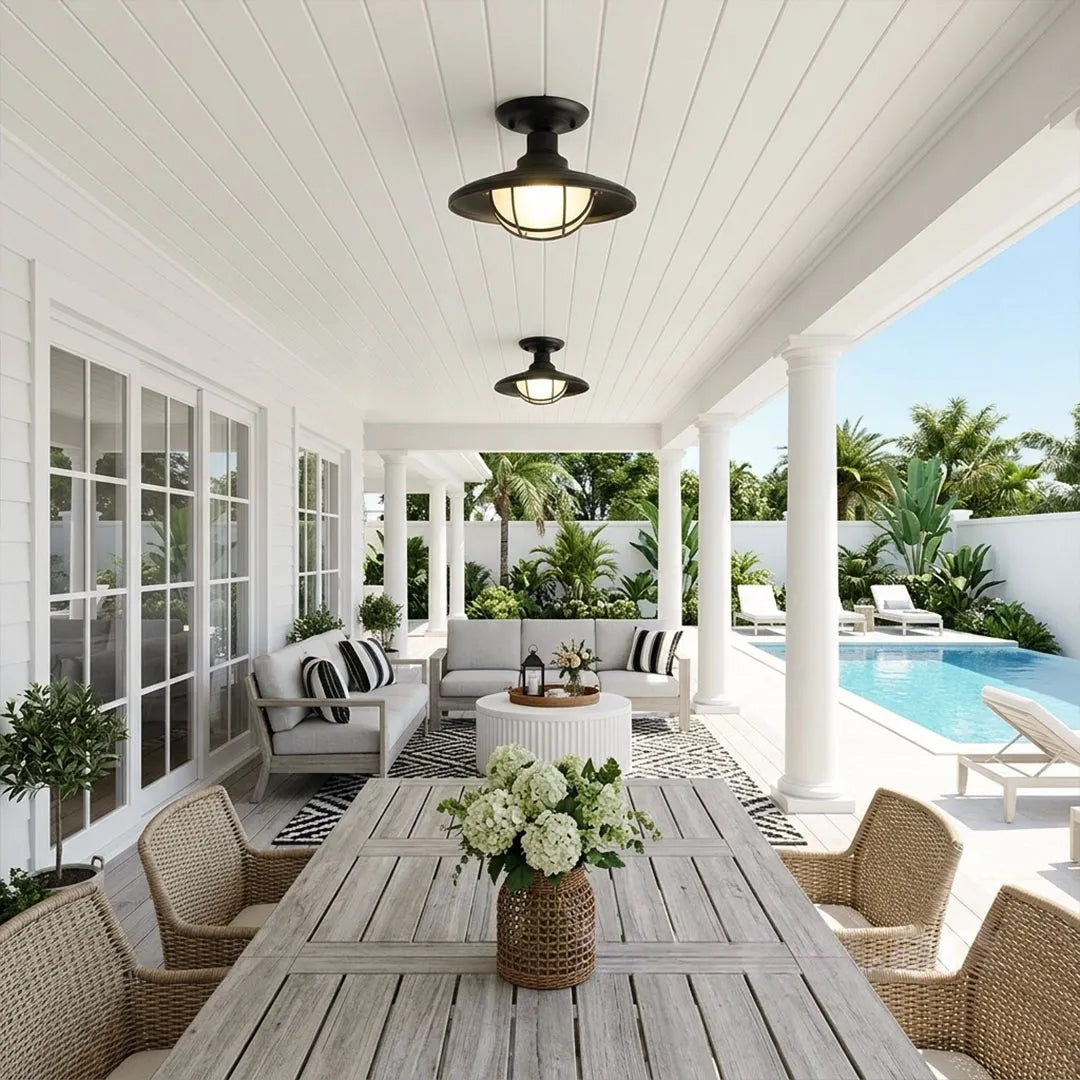 Black semi flush ceiling light installed above an outdoor dining table on a bright covered patio by the pool.