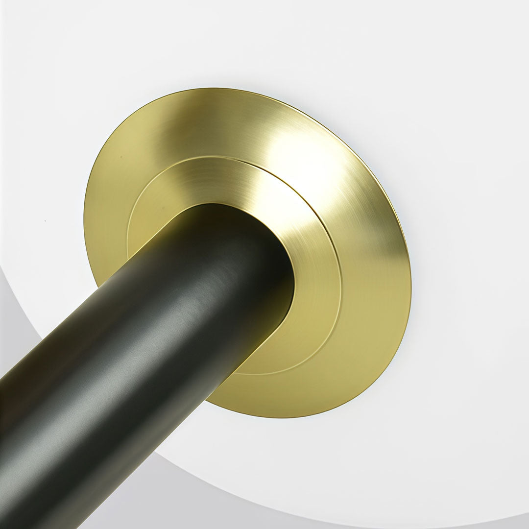 Close-up of the canopy and stem detail on a black semi flush mount light with brass trim.