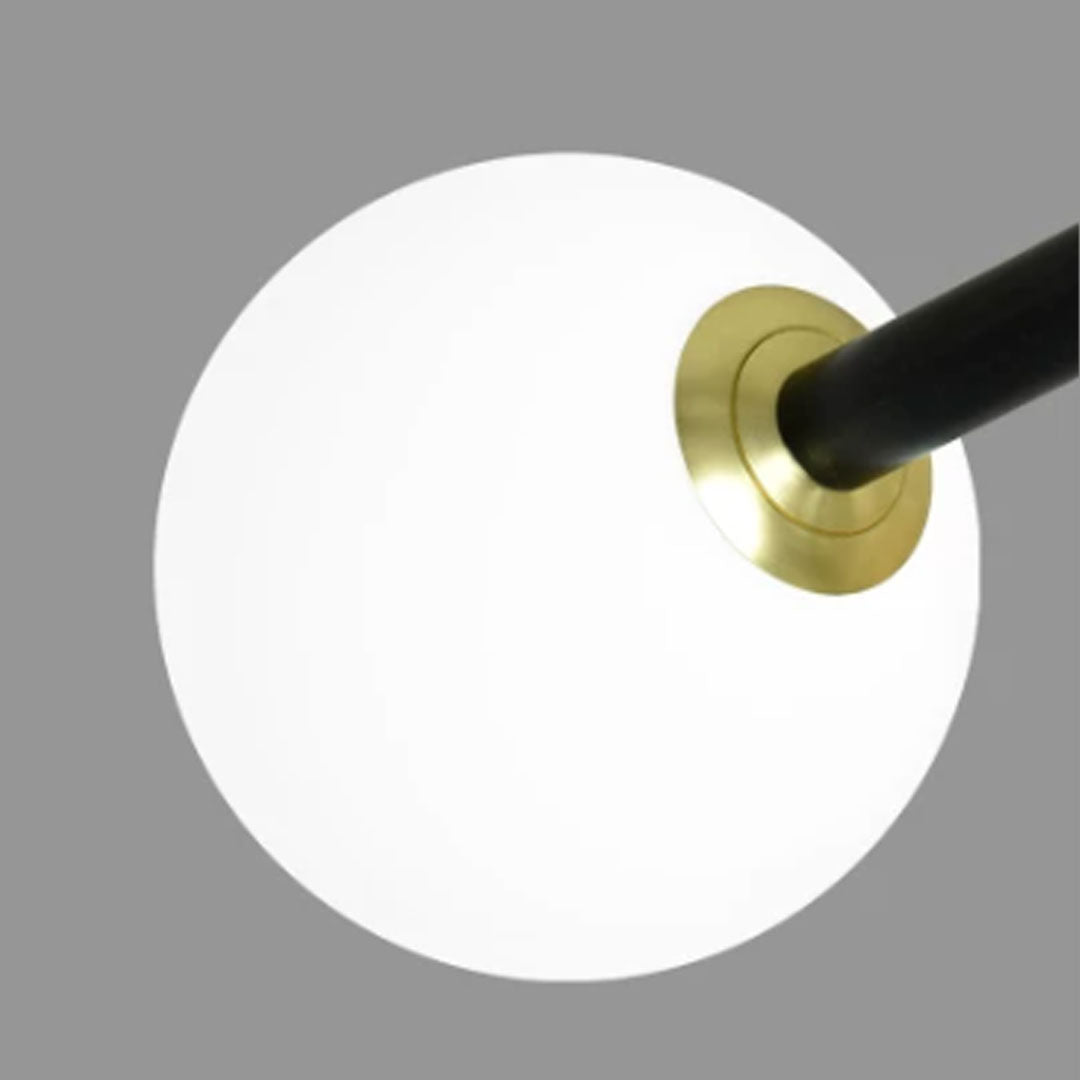 Close-up of a black semi flush mount light showing a frosted globe shade with a brass accent and black frame.
